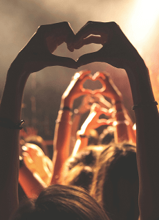 Several pairs of raised arms in a crowd